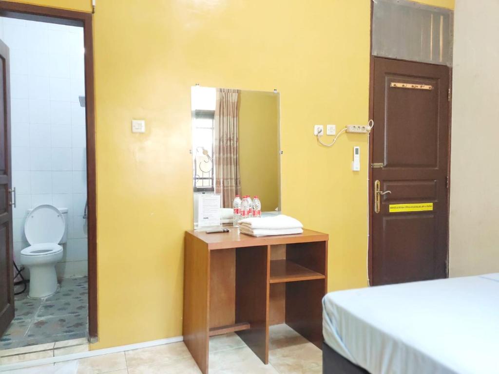 NgabeanOmah Cahyo Homestay的客房设有带镜子的书桌和卫生间