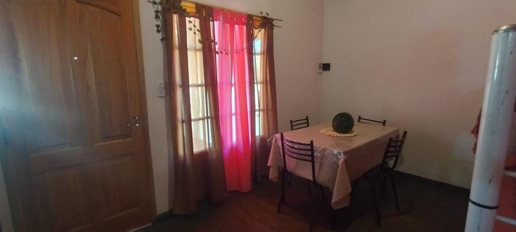 una camera con tavolo e tenda rosa di Cabañas el Cortijo a Tunuyán