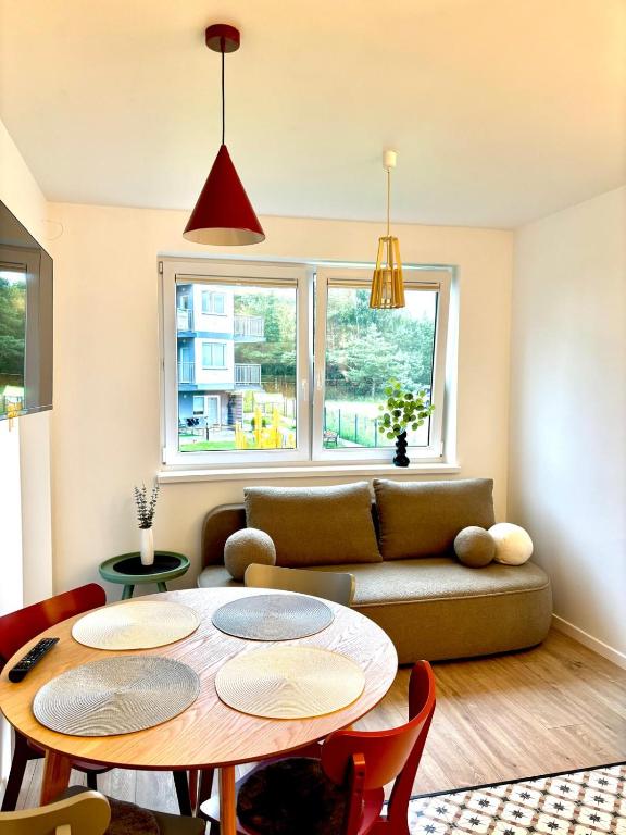 a living room with a couch and a table at Dębina Spot 27 in Debina