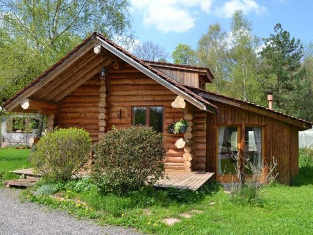 a log cabin with a porch in the grass at Chalet en Rondins Au Cœur de la Nature avec Confort Moderne près de Strasbourg - FR-1-589-228 in Le Saulcy
