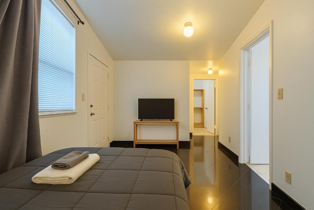 マイアミにあるStylish Wynwood studioのベッドルーム(ベッド1台、テーブル上のテレビ付)