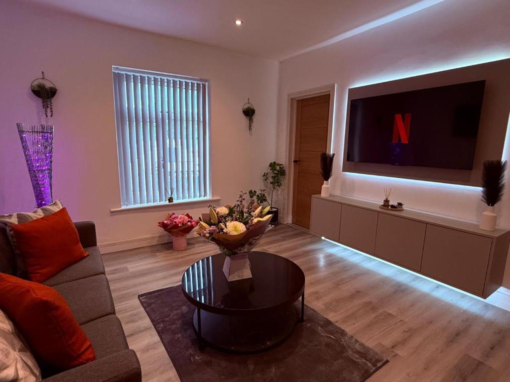 a living room with a couch and a tv at 124B Modern Suite 1 bedroom apartment in Quinton