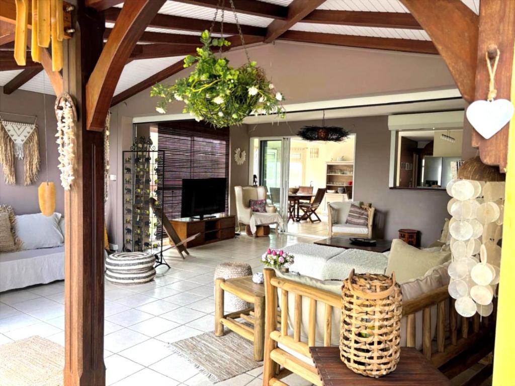 a living room with a couch and a table at Terracota - Spacieux et Chaleureux avec extérieur in Les Trois-Îlets