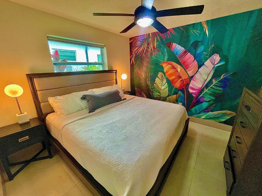 a bedroom with a large bed with a ceiling fan at SuaveMauve Las Olas Beach in Fort Lauderdale