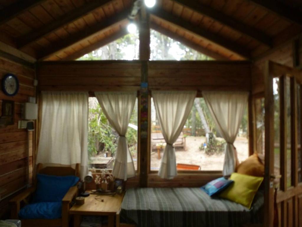 a bedroom with a bed and a large window at Cabaña Kultrum Mar Azul in Mar Azul
