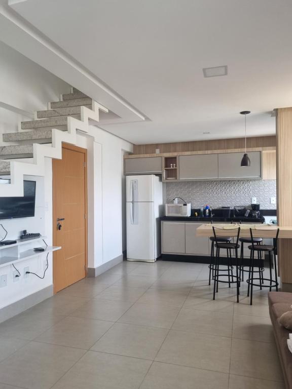 a kitchen and dining room with a staircase at Apartamento Delineado in Ubá