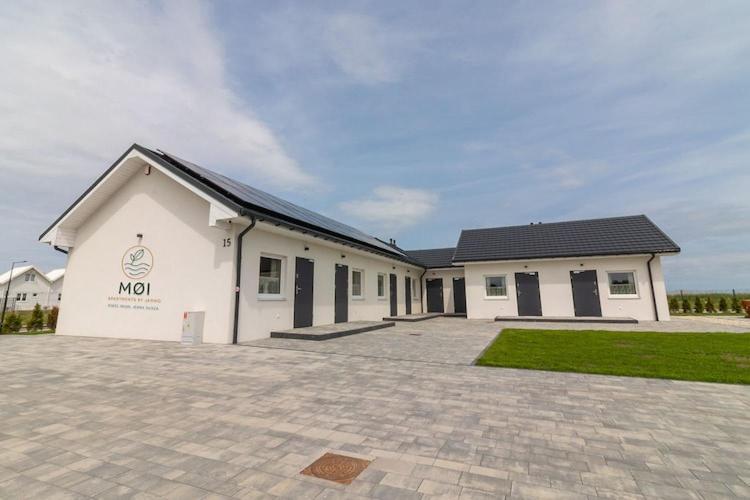 ein großes weißes Gebäude mit einer Einfahrt davor in der Unterkunft Comfortable holiday cottages in Mielno in Mielno