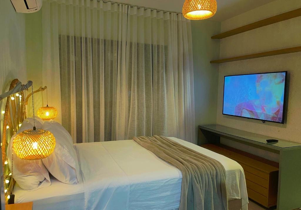 a bedroom with a bed and a flat screen tv at Casa Mar III in João Pessoa
