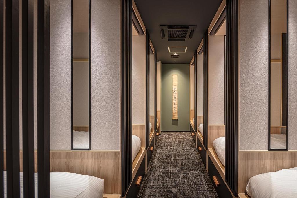 a hallway with beds and mirrors in a room at ENSO TOKYO Akasaka in Tokyo