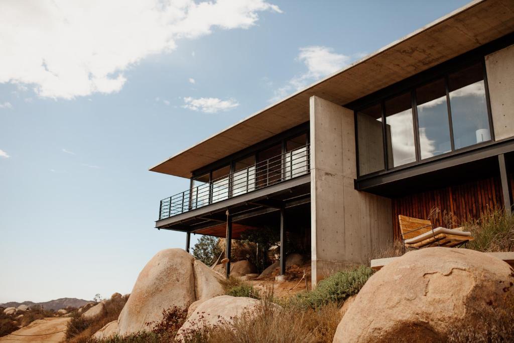 une maison sur une colline avec des rochers devant elle dans l'établissement Villa Gracia, Valle de Guadalupe, à Francisco Zarco