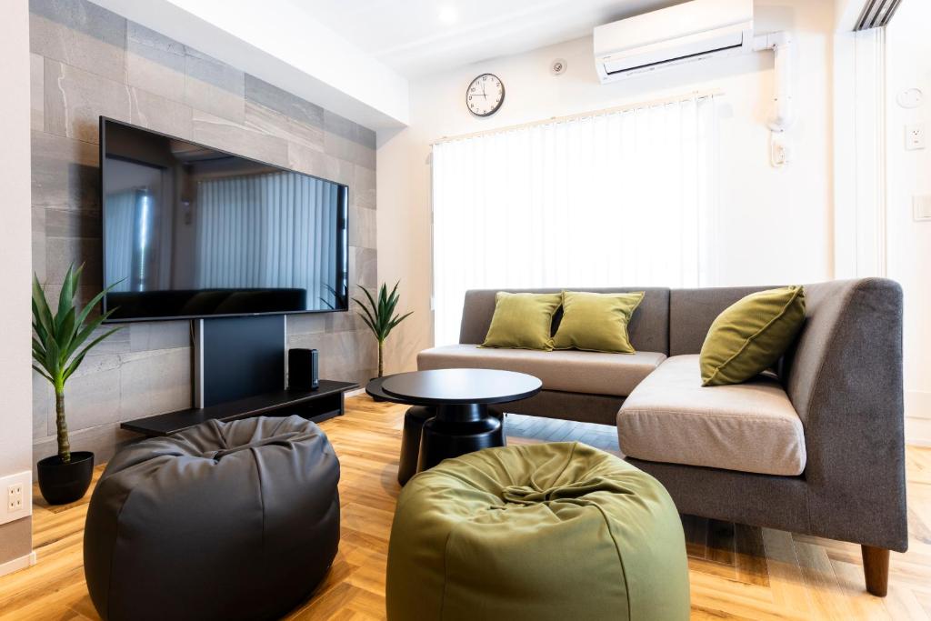 a living room with a couch and a tv at Amp Flat TFK西新駅前 in Fukuoka