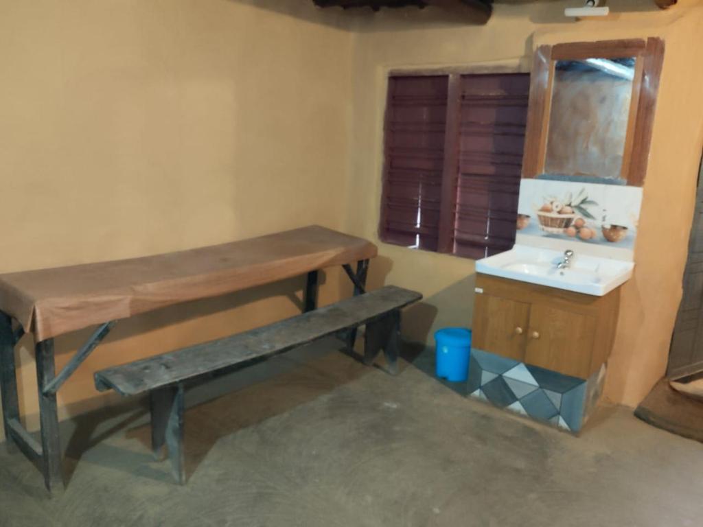 a bathroom with a wooden table and a sink at Natural mudhouse in Kanthalloor