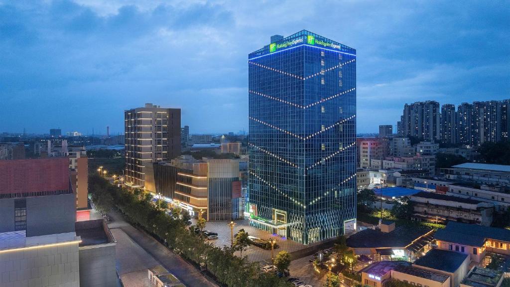 a tall building with lights on it in a city at Holiday Inn Express Foshan Sanshui by IHG in Foshan