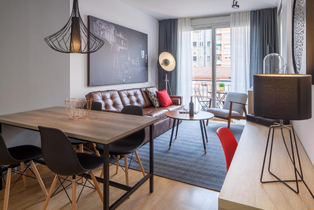 un soggiorno con tavolo e divano di Habitat Apartments Hot Jazz a Barcellona