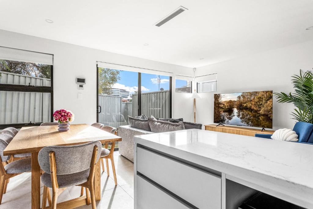 eine Küche und ein Wohnzimmer mit Tisch und Stühlen in der Unterkunft Station & Surf 3BR Wollongong Townhouse in Wollongong