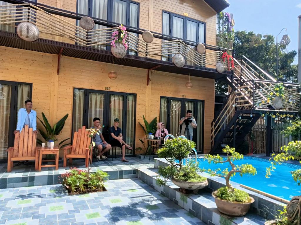 Eine Gruppe von Menschen sitzt auf Stühlen vor einem Haus in der Unterkunft Tamcoc Athletic Bungalow & Restaurant in Ninh Bình
