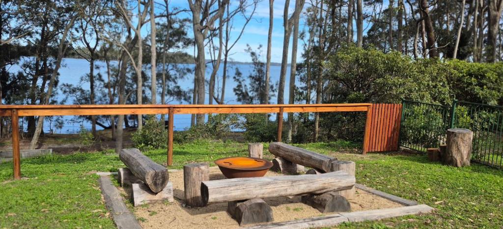 a wooden bench with a toilet sitting in the grass at Waterfront Retreat by Book Jervis Bay Getaway Kayaks, Bikes, Fast Wi-Fi and more in Sanctuary Point