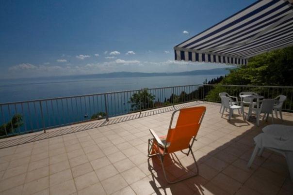 an orange chair sitting on a patio overlooking the ocean at Maslov Apartments in Ohrid