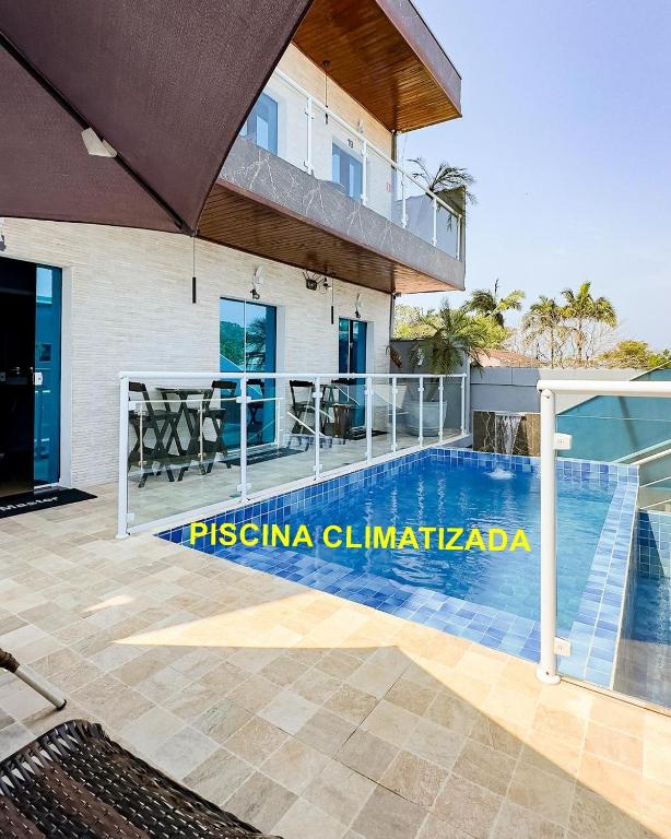 a villa with a swimming pool and a house at Pousada Papito Ubatuba - Praia Perequê-Açu in Ubatuba