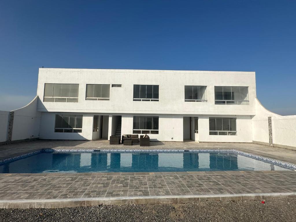 a house with a swimming pool in front of it at CAMPO AZUL Cerro Azul in Cerro Azul