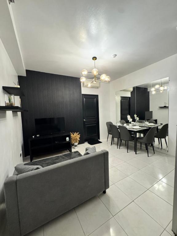 a living room with a couch and a dining room at Condo in Malate in Manila