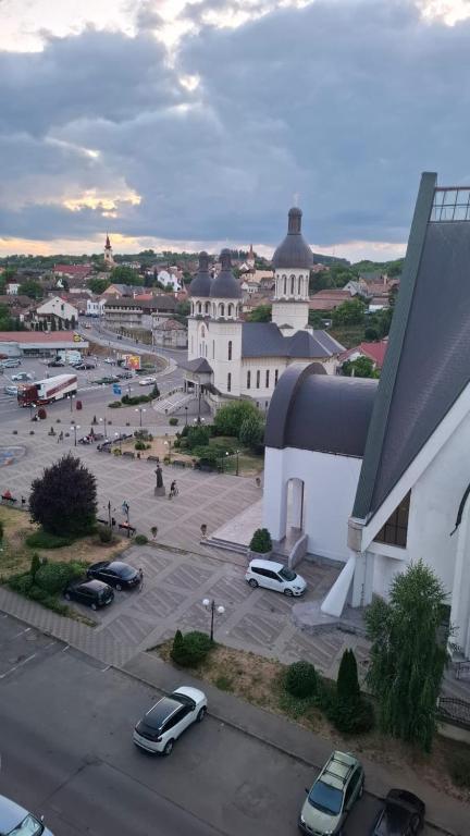 a building with cars parked in a parking lot at Boho Chic Apartament in Reghin