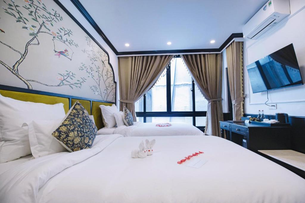 : Phòng nghỉ tại The Orchid Premium Hotel được thiết kế theo phong cách modern classic, có cửa kính lớn, nội thất trang nhã và đầy đủ tiện nghi, phù hợp cho cặp đôi hoặc khách nghỉ 2–3 đêm tại Huế.