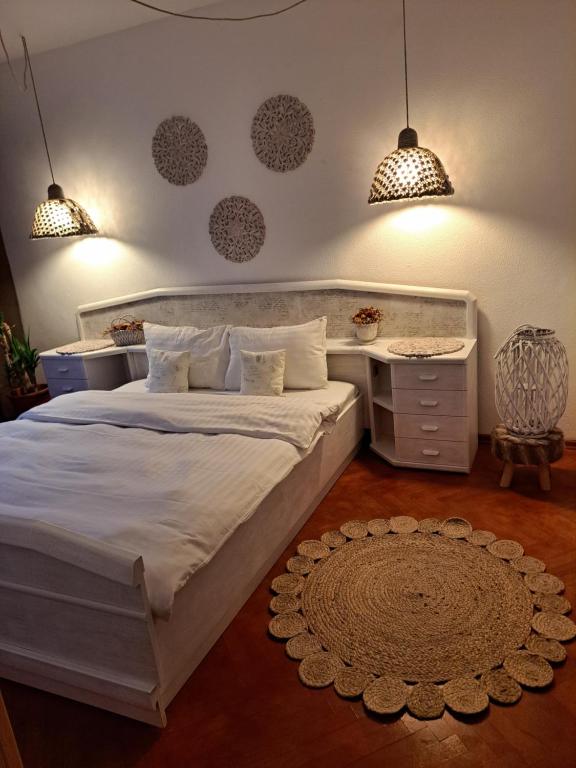 Un dormitorio con una gran cama blanca y dos lámparas. en Boho Chic Apartament, en Reghin