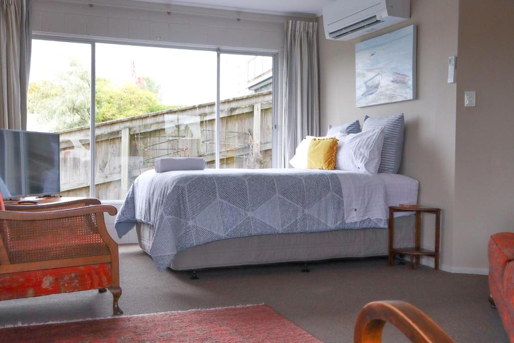 een slaapkamer met een bed en een groot raam bij Harbour Views in Taupo