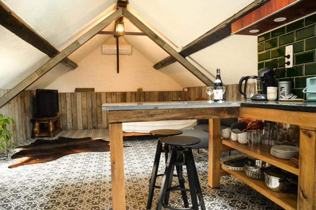 a kitchen with a loft with a counter and stools at Luxe loft in vierkantshoeve in Sint-Truiden
