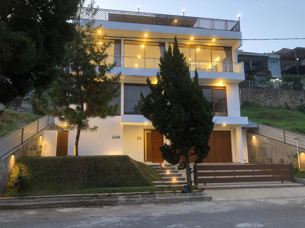 a large white house with lights on it at Dwell Guesthouse Dago in Ciburial