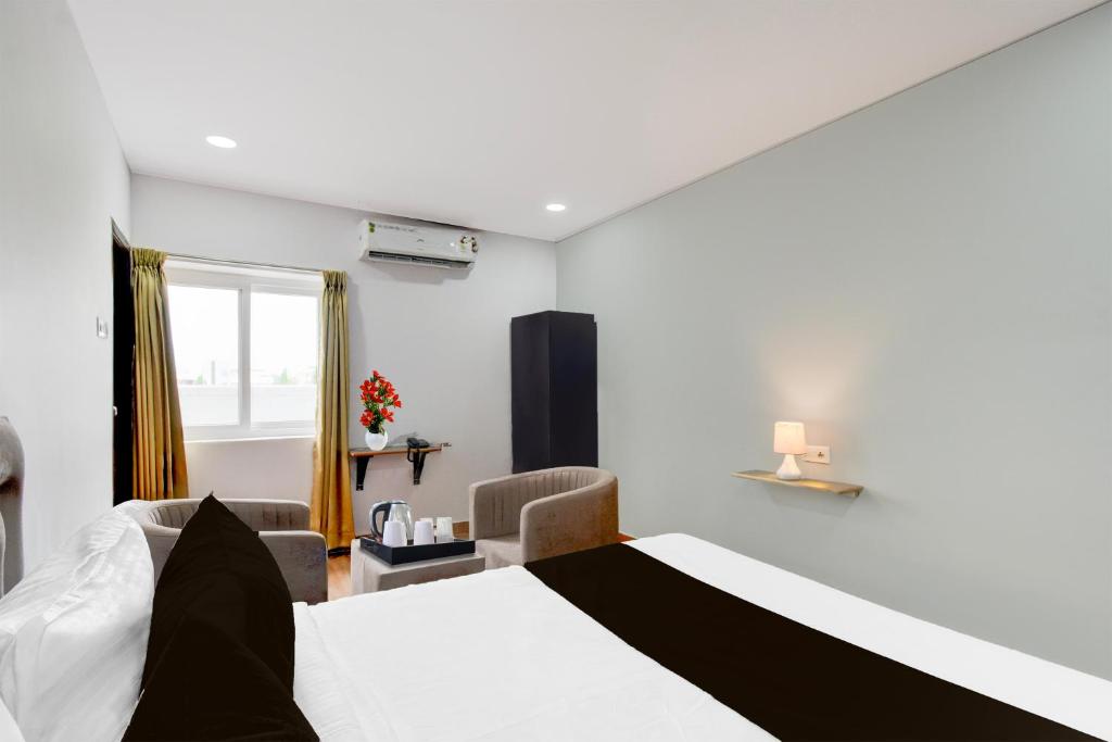 Super Townhouse B N Reddy Formerly Capitol Stay Inn في Surūrnagar: غرفة فندق بها سرير ونافذة