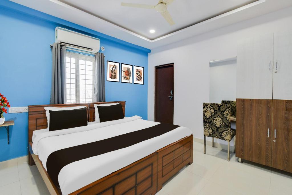 a bedroom with a large bed and a chair at Super Townhouse Hitech City Madhapur in Hyderabad