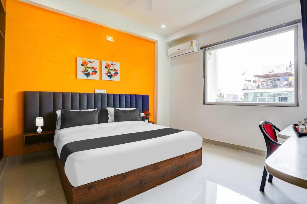 a bedroom with a bed with an orange wall at Super Townhouse Sector 69 Gurgaon in Gurgaon