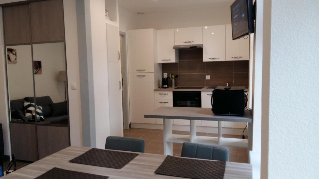 eine Küche mit einem Tisch und Stühlen im Zimmer in der Unterkunft Tripiers Duplex in Colmar