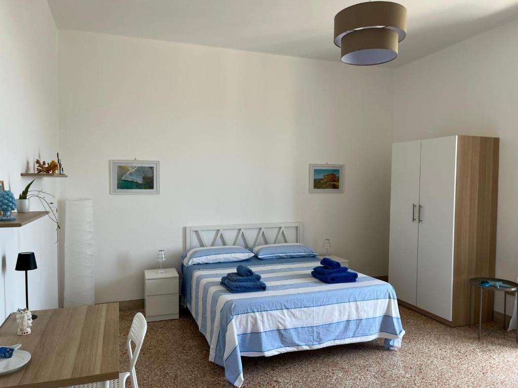a bedroom with a bed with blue towels on it at Fronteporto in Porto Empedocle