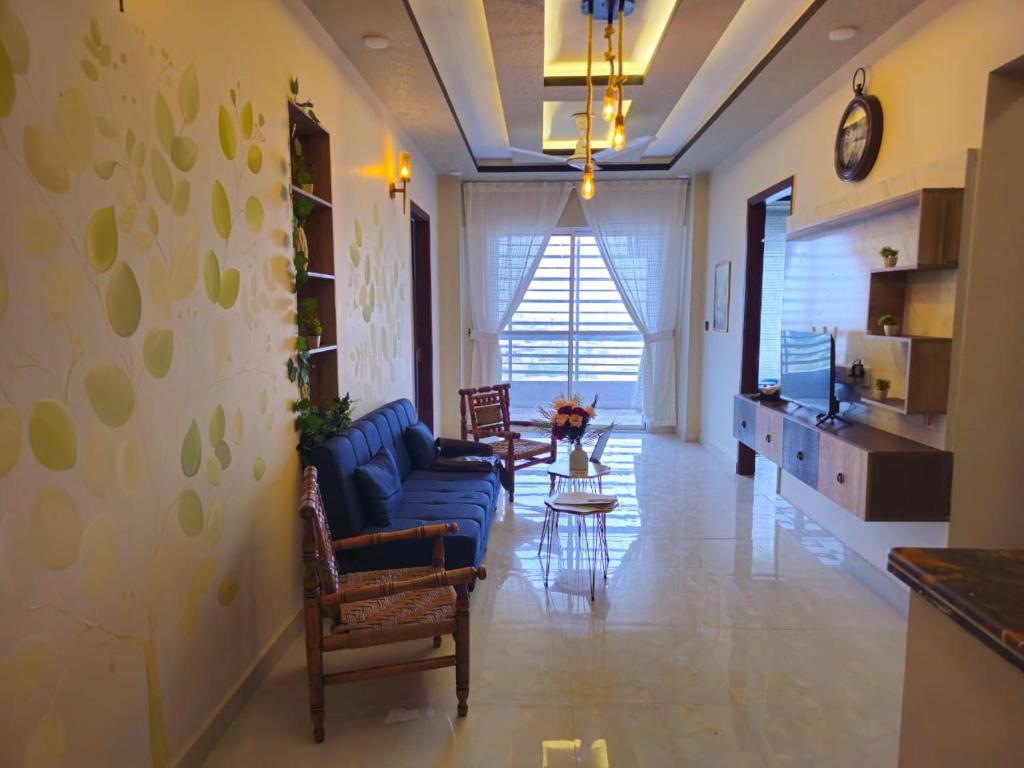 カラチにあるEynn Aparthotels - Service Apartments x Gulistan-e-Johar Block 16の青いソファと椅子のあるリビングルーム