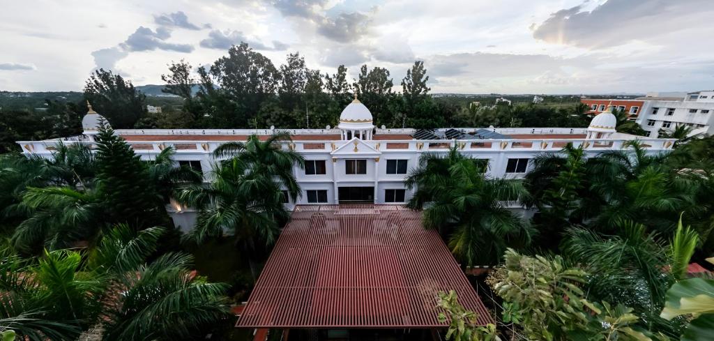 an aerial view of a white building with palm trees at Jal Mahal Resort and Spa in Mysore