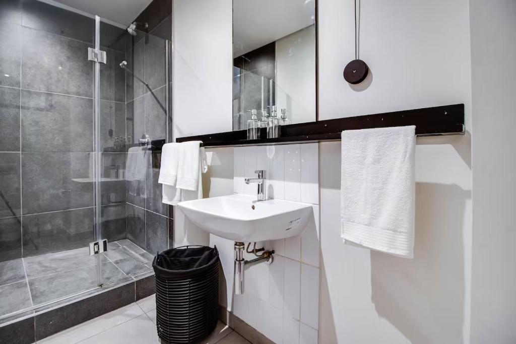 a white bathroom with a sink and a shower at Celestial Lux Boho Home in Johannesburg
