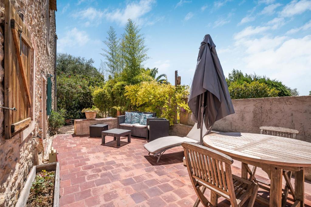 une terrasse avec une table en bois et un parasol dans l'établissement Bastidon la Deprat, à Sanary-sur-Mer