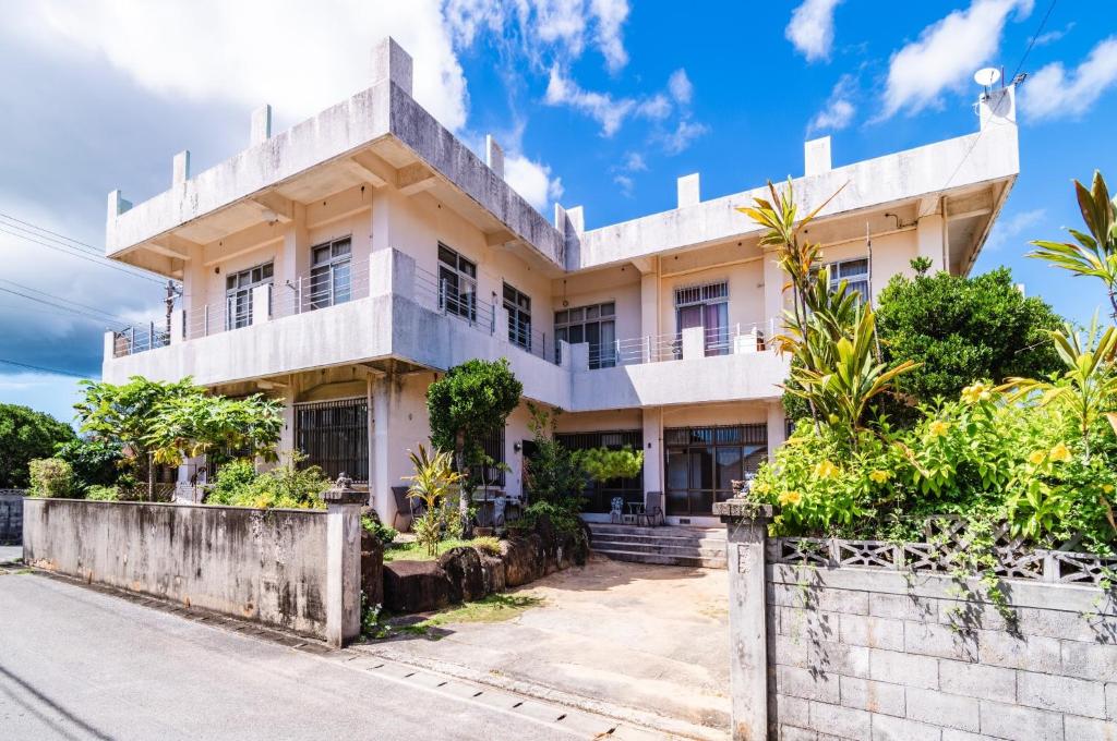 a large white building with trees in front of it at Kumi No Yado Gettou - Vacation STAY 31704v in Kadekaru