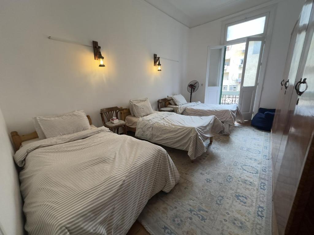 a room with three beds and a window at Granada private bedroom for men only in Alexandria