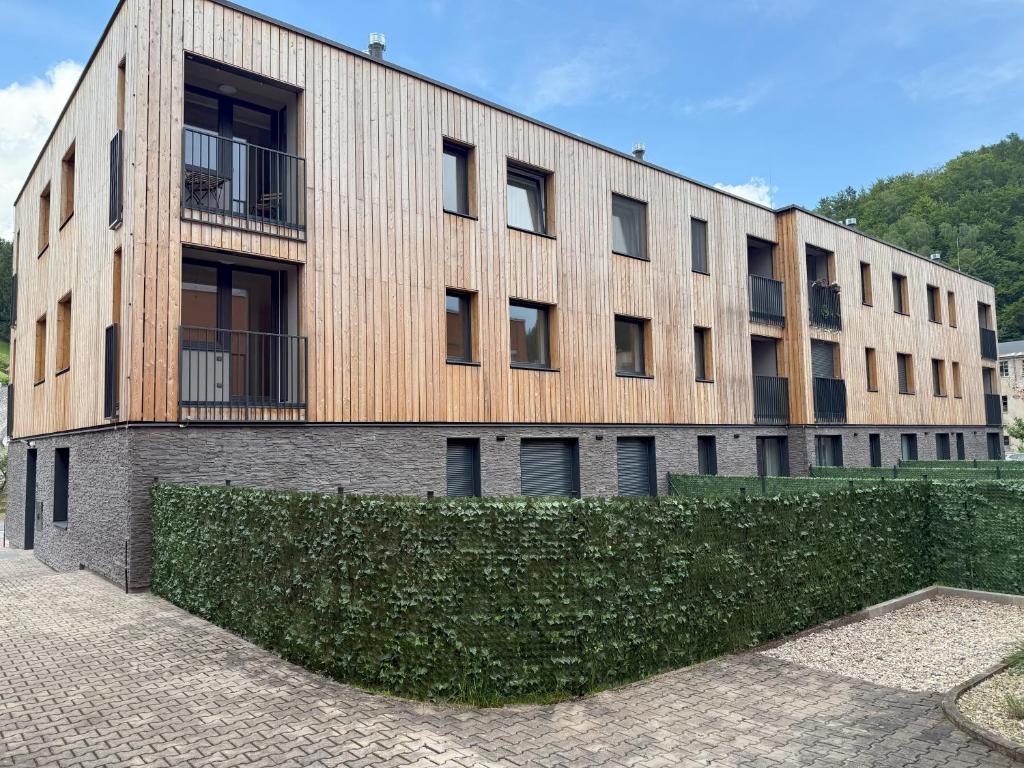 a building with a hedge in front of it at Verde Apartment in Svoboda nad Úpou