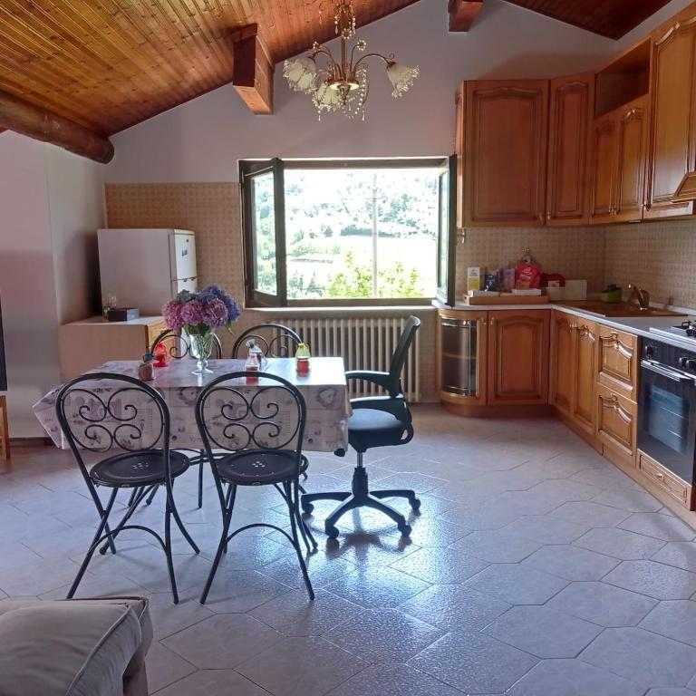a kitchen with a table and chairs in a kitchen at Casa vacanze Ca' Rizzoli in Berbenno