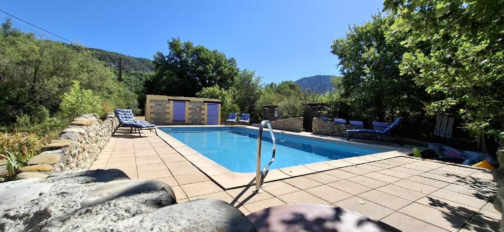 a swimming pool with two chairs next to at Maison Provençale avec piscine in Estoublon