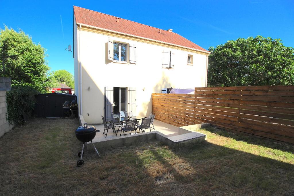 a white house with a fence and a grill at Maison - Proche RER - Jusqu'à 6 Personnes in Saint-Michel-sur-Orge