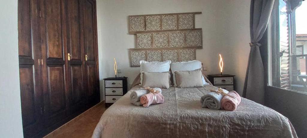 a bedroom with a bed with two stuffed animals on it at Aretina's Lanzarote Retreat in Costa Teguise