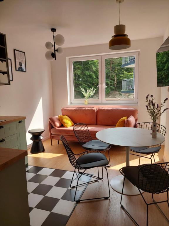 a living room with a couch and a table and chairs at Dębina Lounge 20 Apartamenty in Debina