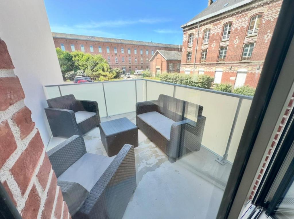 a balcony with two chairs and a couch at Charles - Appartement 6 pers avec Parking et Balcon à deux pas de la plage in Berck-sur-Mer