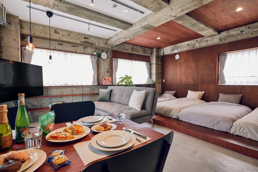 a living room with a table and a couch and a bed at Koubanoyado in Tokyo